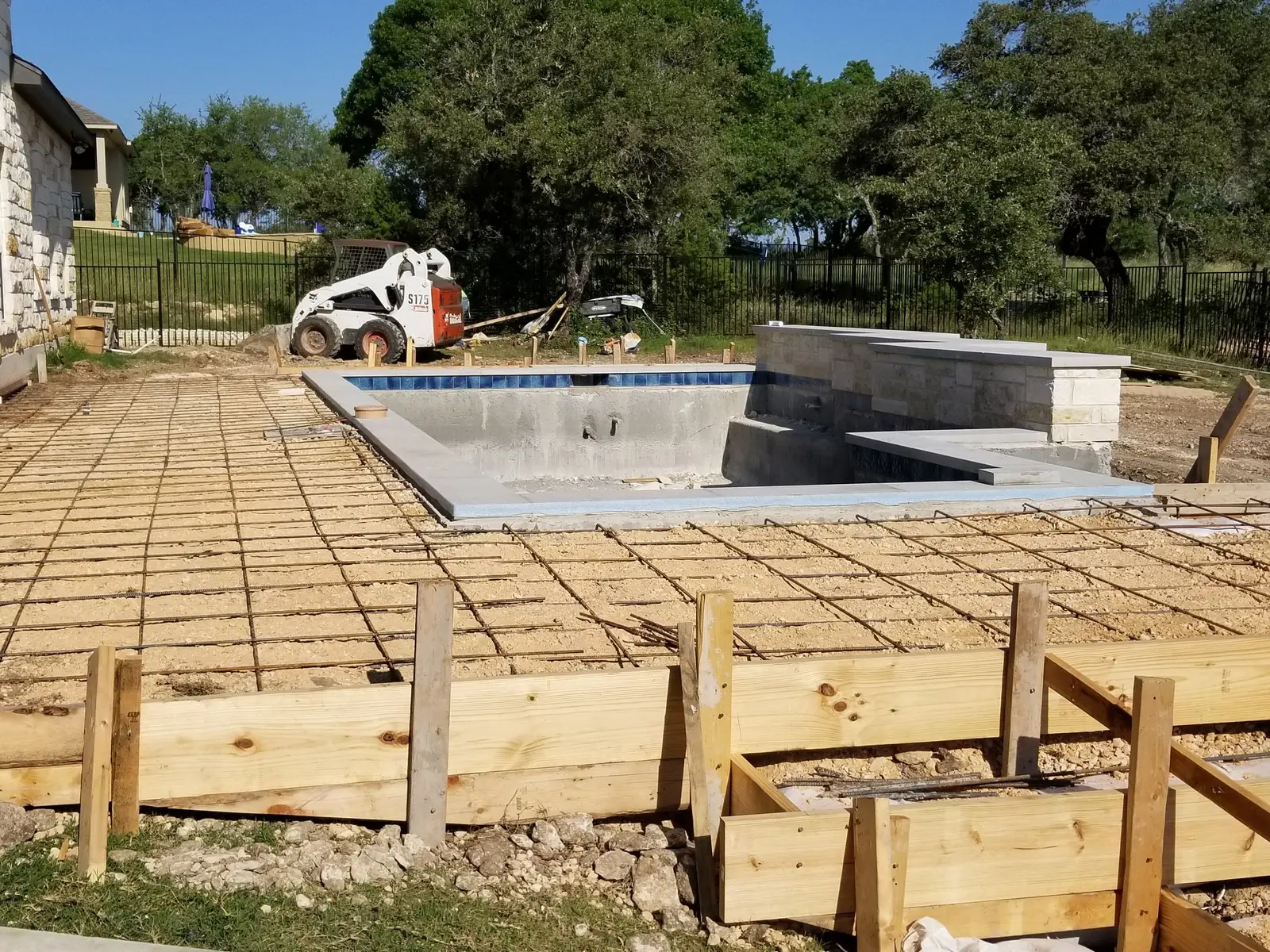 Deck forms and steel grid laid out around a new pool