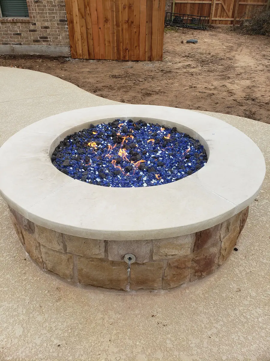 Round stone fire pit with blue fire glass