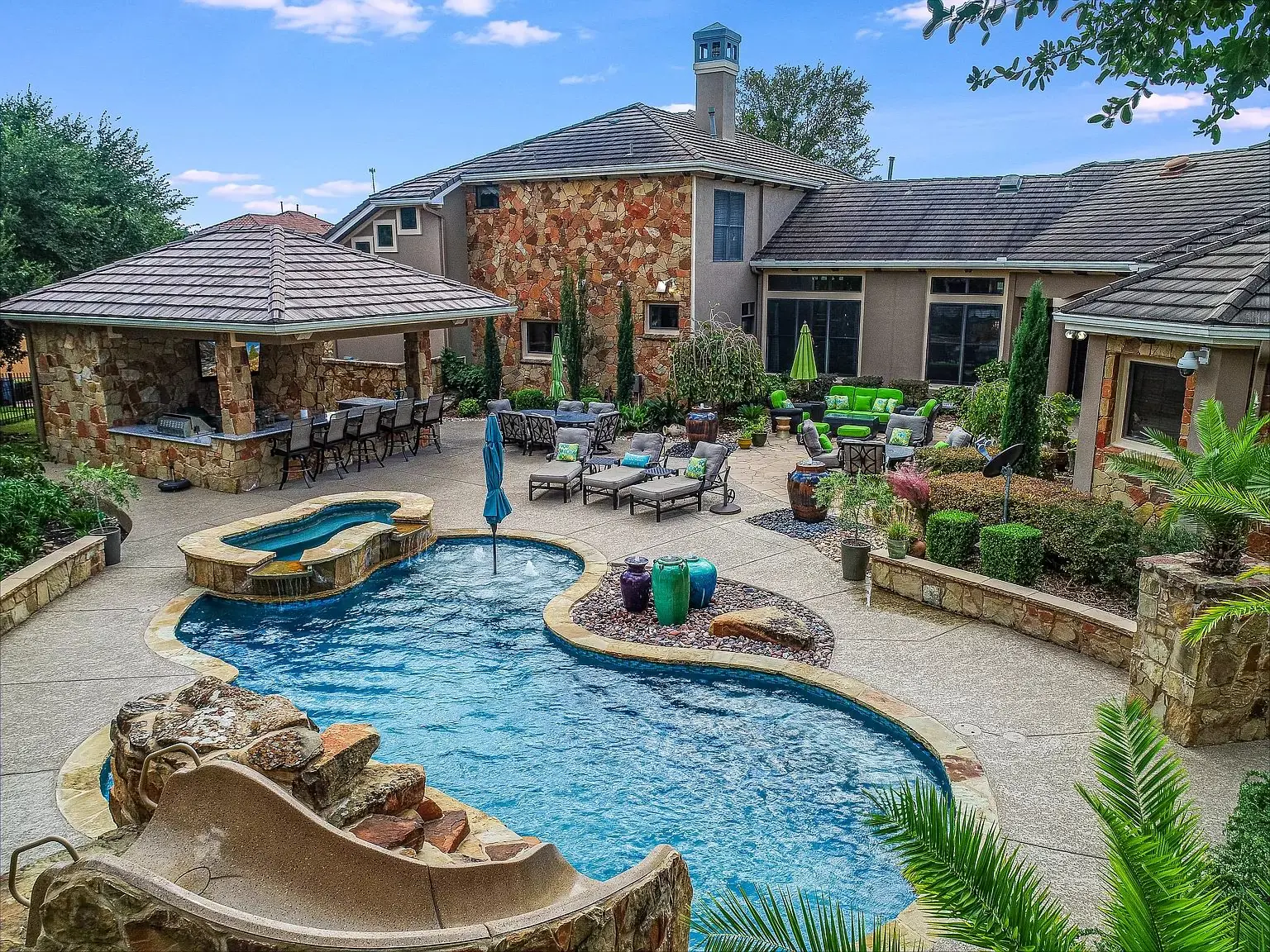 Freeform pool beside a stone pavilion