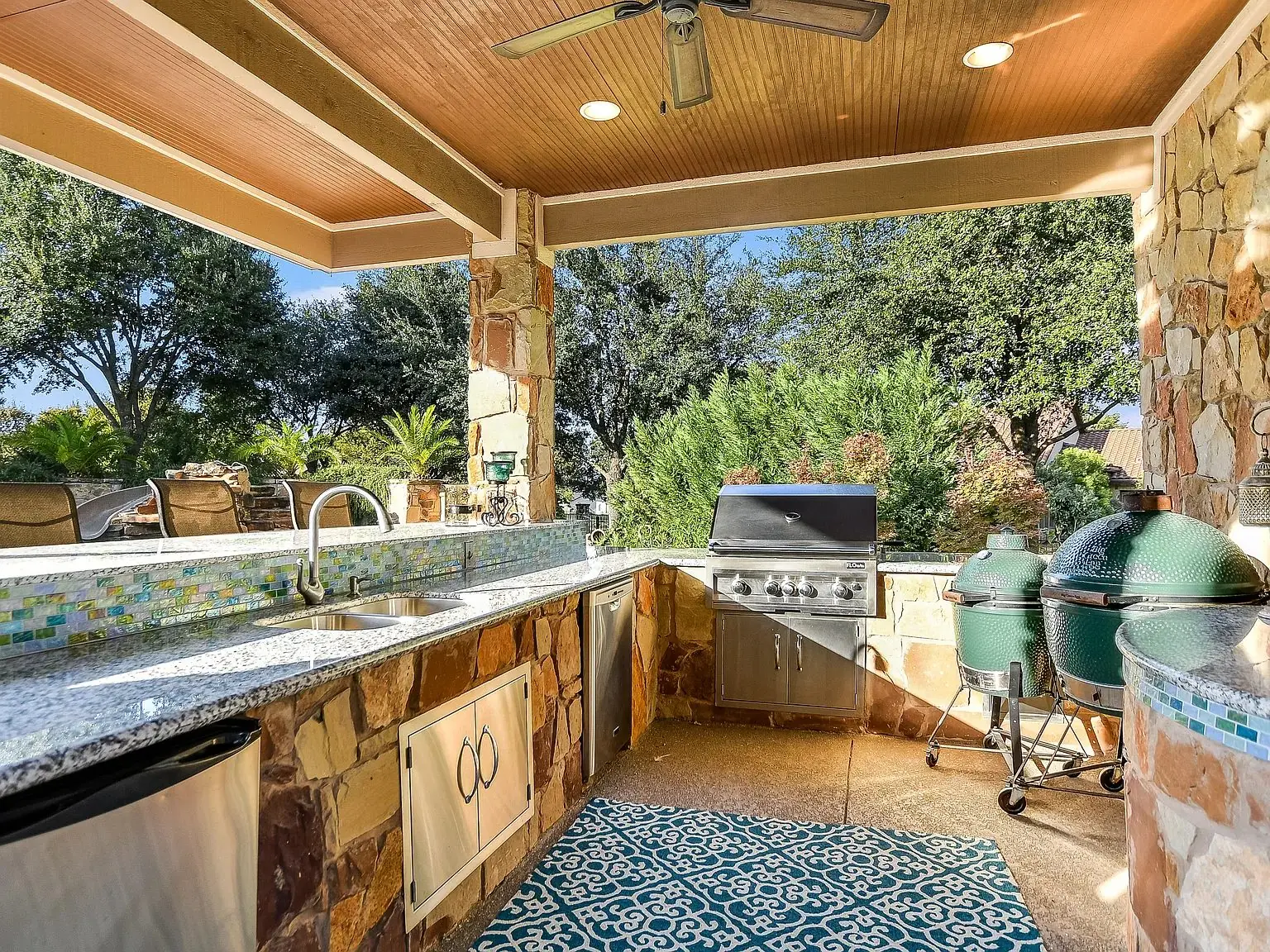 Covered outdoor kitchen with stone counters