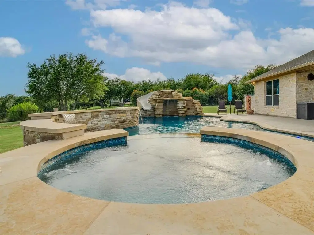 Round shallow pool with a rock waterfall behind