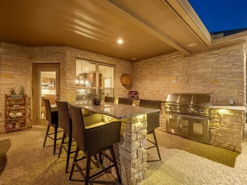 Outdoor kitchen and bar under a covered patio