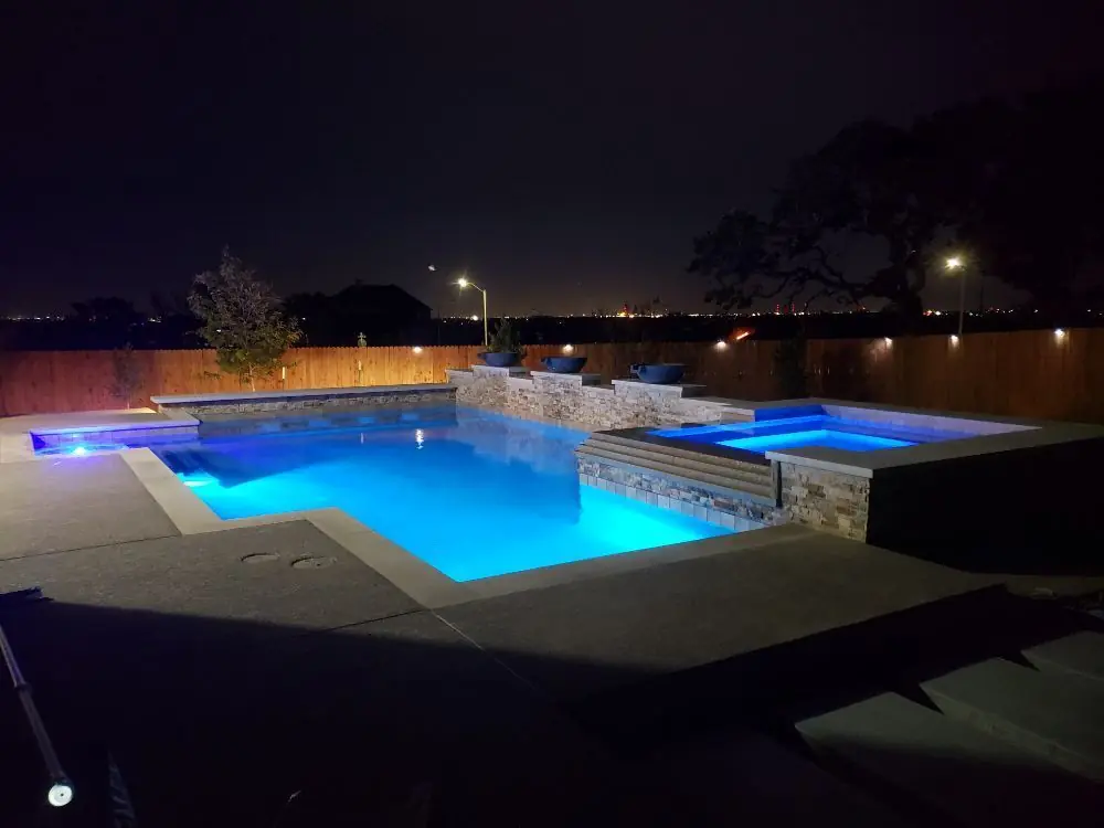 Geometric pool and spa lit at night